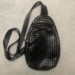 Woman’s Shiny Black Woven Sling Bag With Gold Hardware